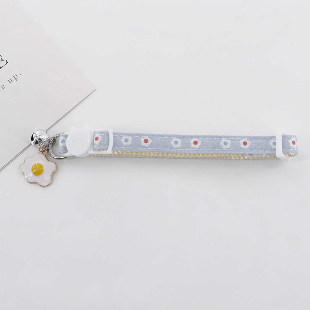 Light blue daisy cat collar with cat-face buckle, bell and fried egg charm