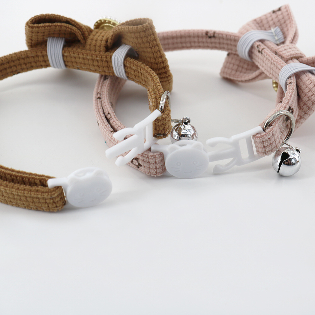 Close-up of the white cat-face buckles, bell loops and collar bows