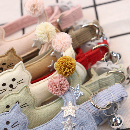Close-up of pom-pom tails, glitter star accents and bells on assorted cat collars