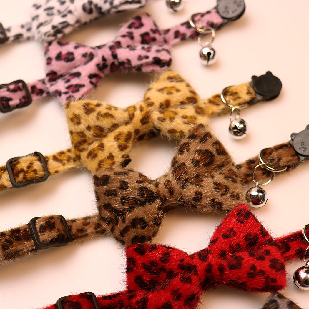Close-up of leopard-print collar bows, bells and cat-face buckles