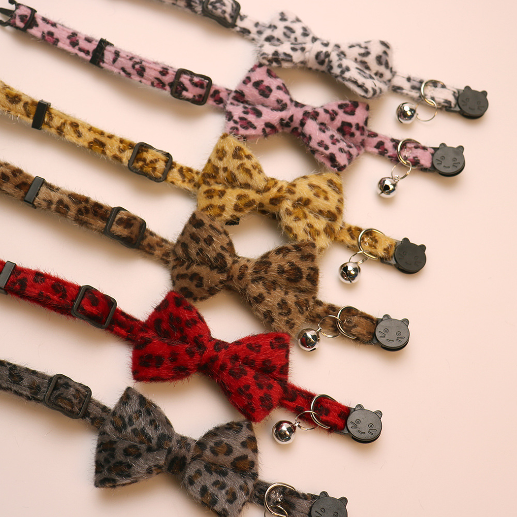 Six leopard-print bow cat collars showing adjusters, bells and cat-face buckles