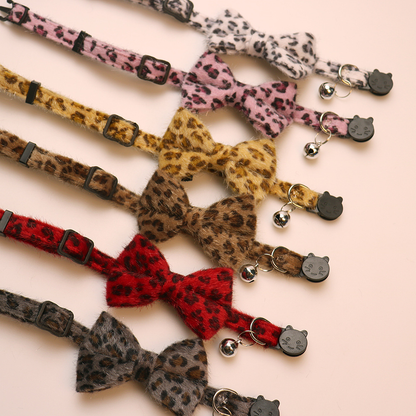 Six leopard-print bow cat collars showing adjusters, bells and cat-face buckles