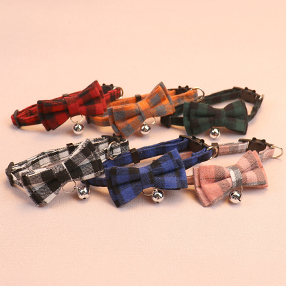 Six plaid bow cat collars with hanging bells displayed together
