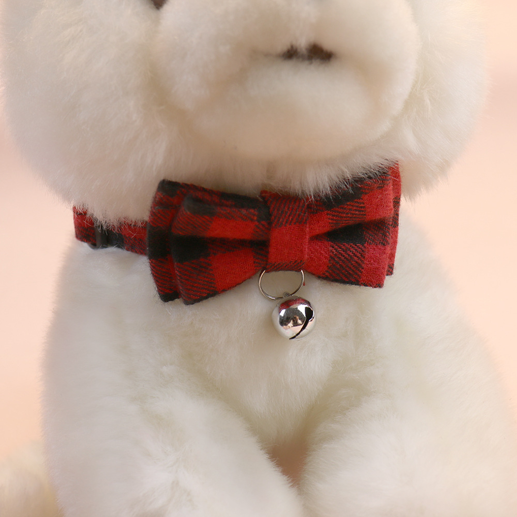 Red plaid bow cat collar with bell displayed around a plush cat model