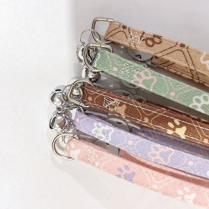 Close-up of patterned collar straps, stitching and metal-tone attachment rings