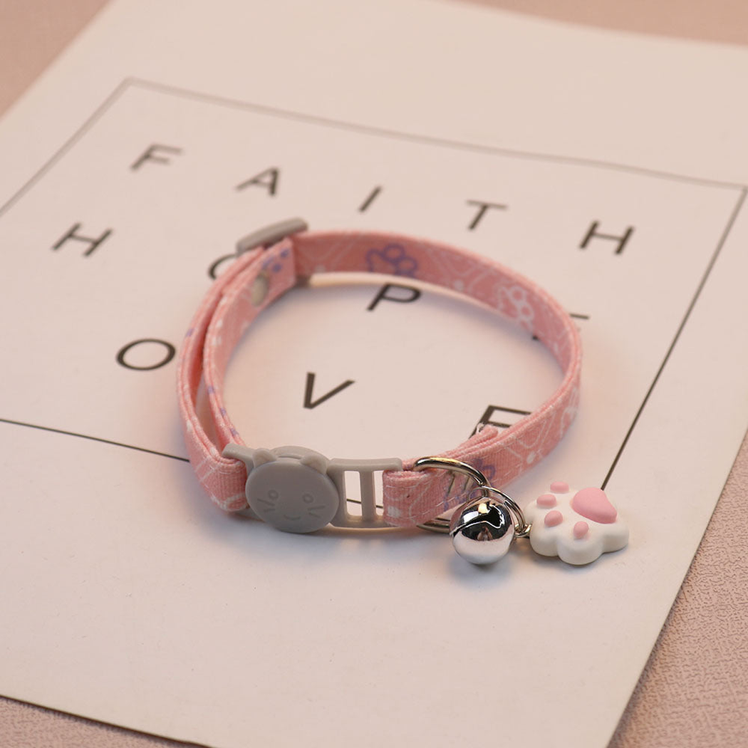 Light pink patterned cat collar with cat-face buckle, bell and paw-shaped charm