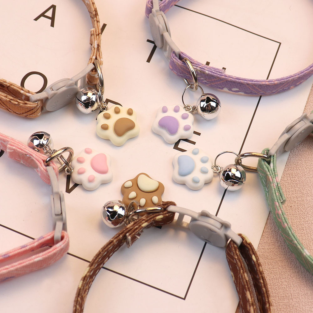 Close-up of cat-face buckles, bells and paw-shaped charms in five colors