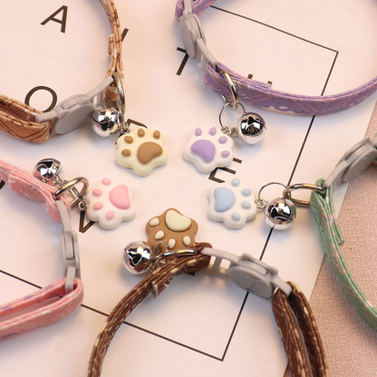 Close-up of cat-face buckles, bells and paw-shaped charms in five colors