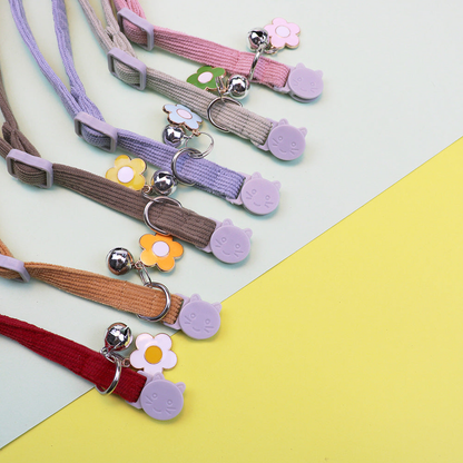 Close-up of adjustable cat collars with cat-face buckles, rings, bells and flower charms