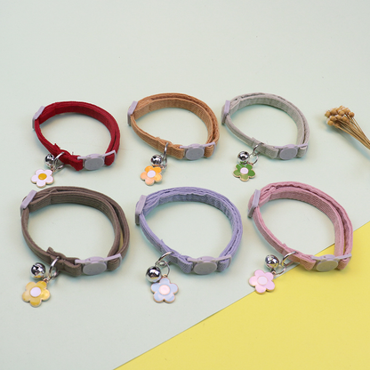 Six colorful cat collars arranged in loops with flower charms and bells
