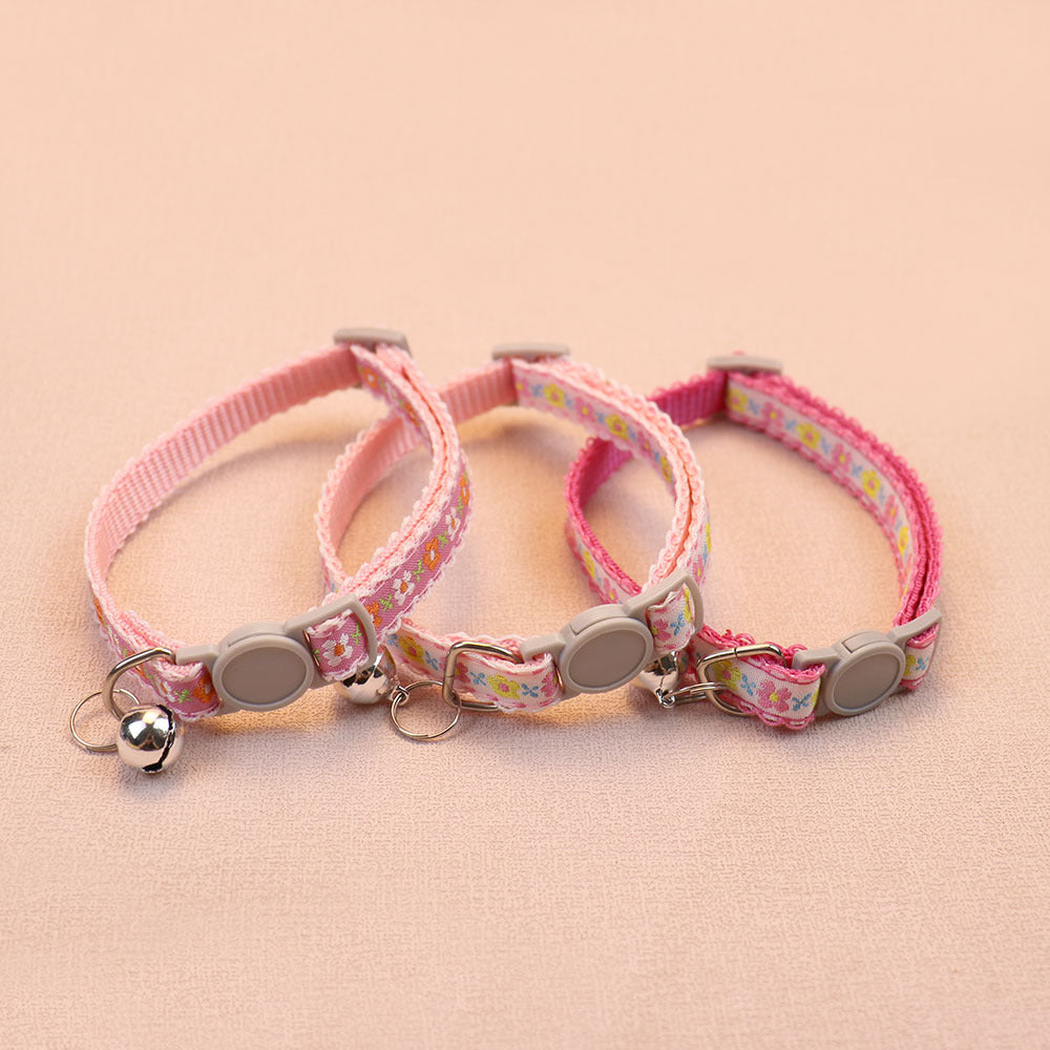 Three pink floral cat collars with bells and round buckles