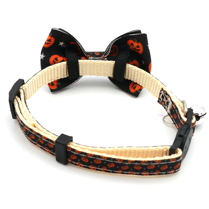 Back view of a black pumpkin-print bow cat collar showing the bow loops and buckle