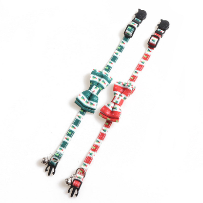 Red and dark green bow cat collars laid flat to show their adjustable straps and bells