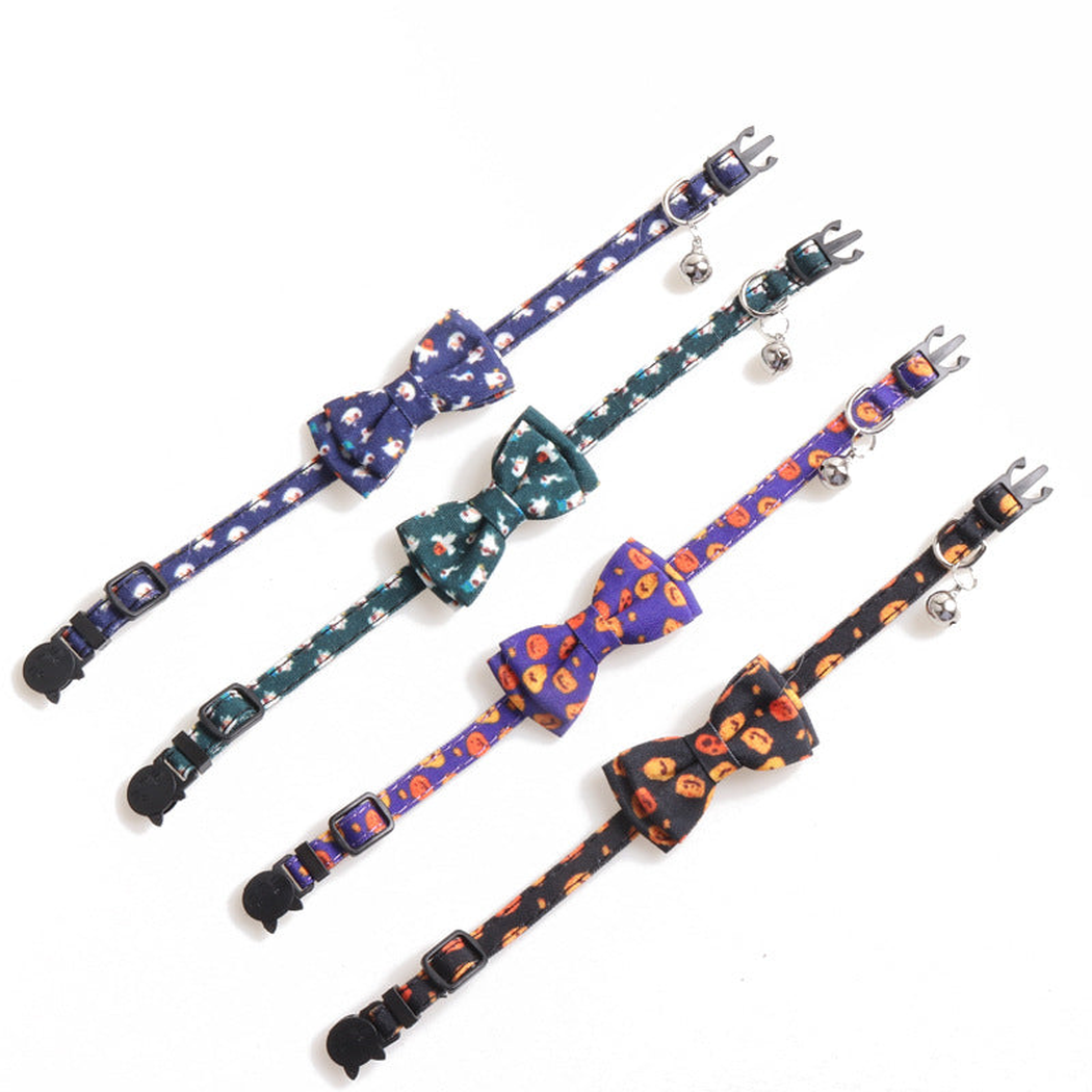 Four bow cat collars in pumpkin and ghost prints laid out at full length