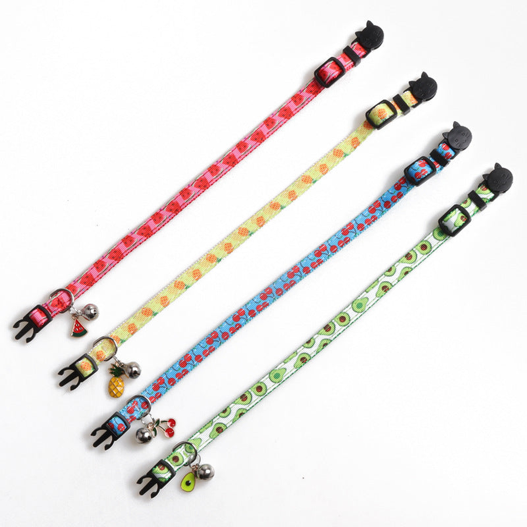 Four fruit-pattern cat collars laid flat to show their adjustable straps and hardware