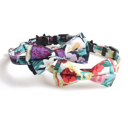 Two floral cat collars with matching bows displayed together