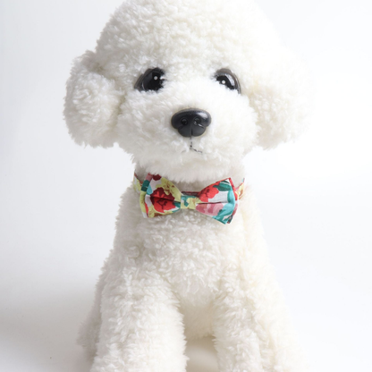 Floral bow cat collar displayed on a white plush animal model