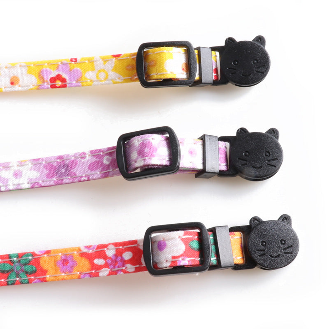Close-up of cat-face buckles and strap adjusters on three floral collars
