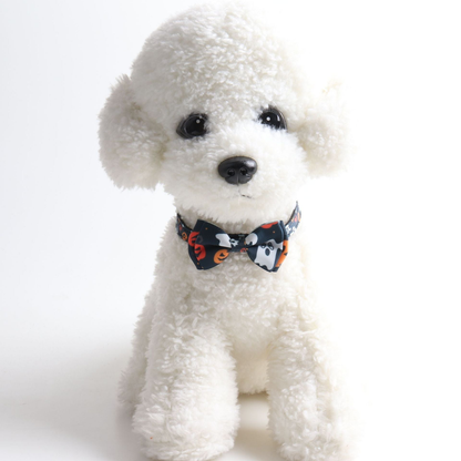 White dog wearing a black pumpkin-and-ghost bow collar