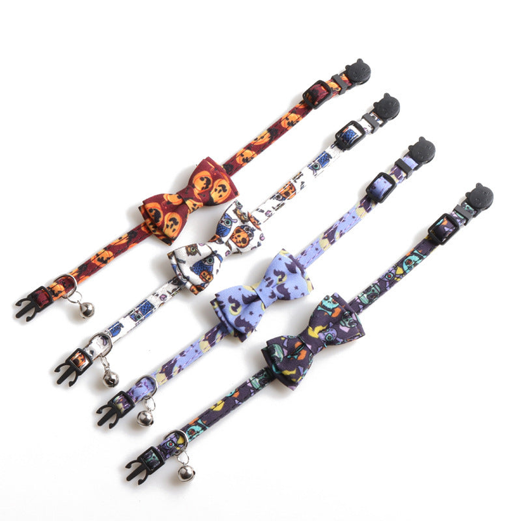 Four printed bow cat collars with bells displayed together