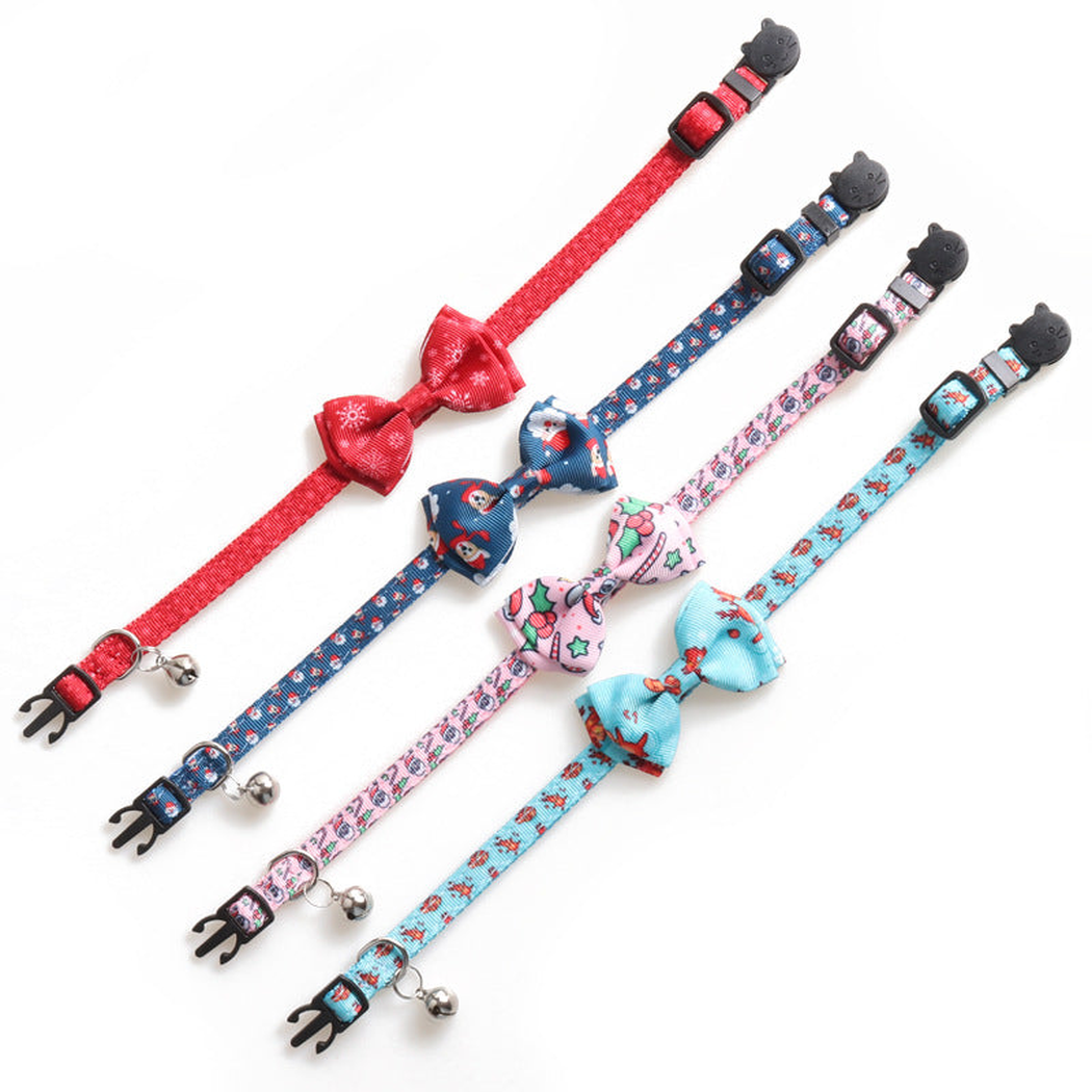 Four patterned bow cat collars laid flat to show the straps, buckles and bells