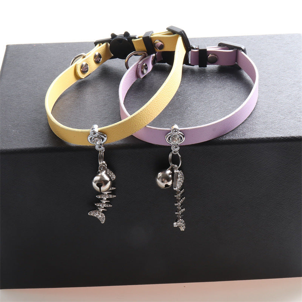Yellow and light purple cat collars with bells and dangling fishbone charms