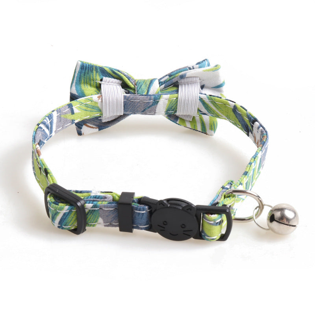 Green leaf-print bow cat collar showing the buckle, adjustment slider, and bell