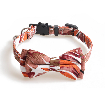 Orange-red leaf-print cat collar with bow, bell, and cat-face buckle