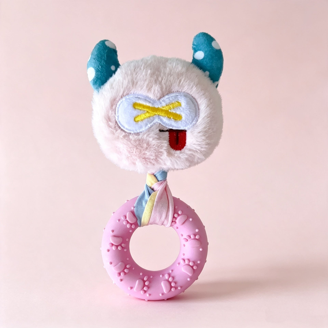 Light pink monster-face ring dog toy with crossed-eye design, front view