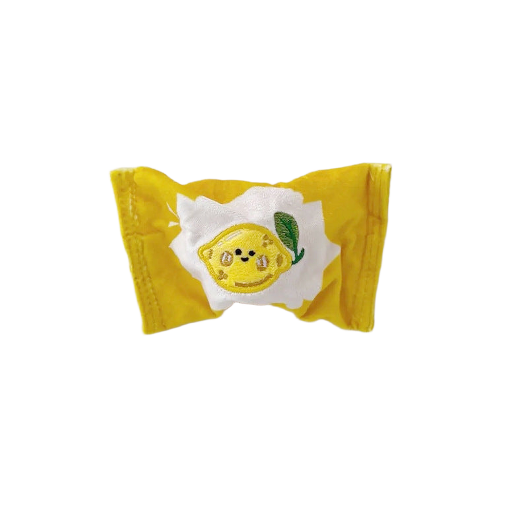 Yellow candy-shaped dog toy with lemon face patch, front view