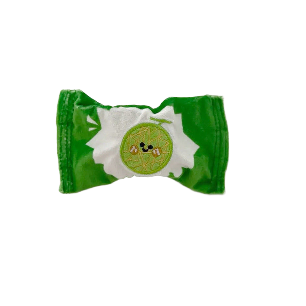Green candy-shaped dog toy with melon face patch, front view