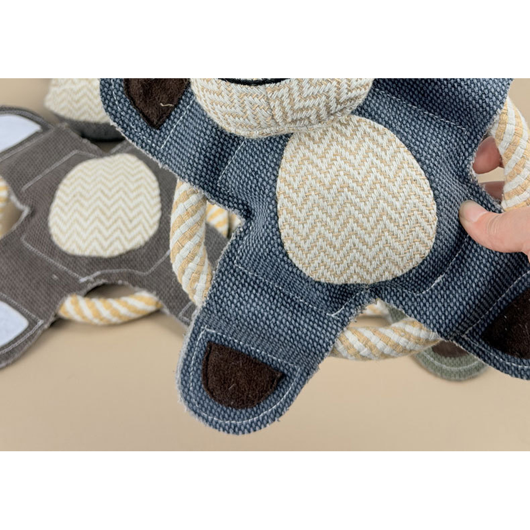 Close-up of the blue-gray monkey toy's stitched body and rope ring