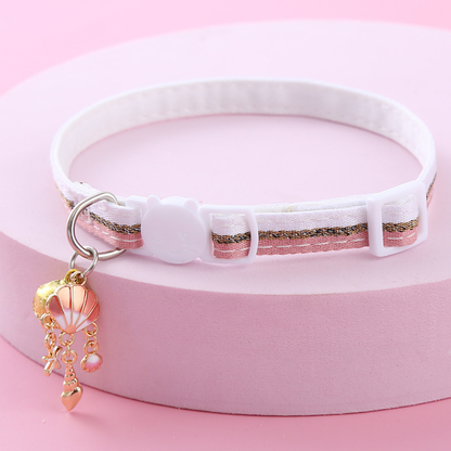 Pink striped cat collar with white cat-face buckle, bell and shell-themed charms