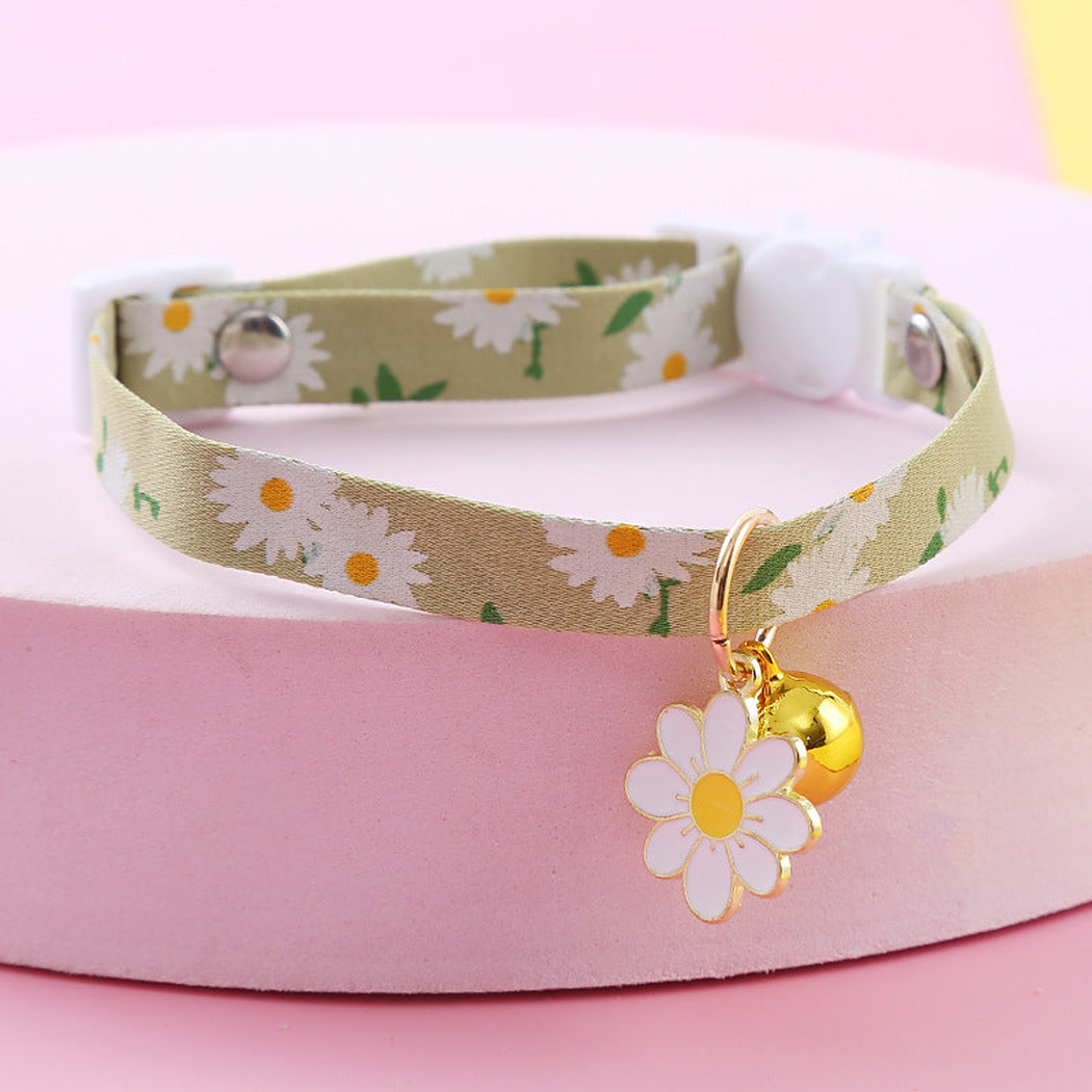 Green daisy-print cat collar with gold-tone bell and white flower charm