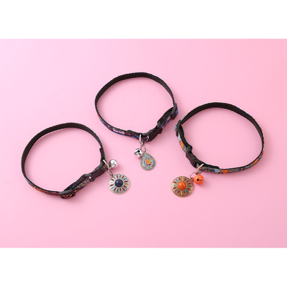 Three multicolor cat collars arranged in loops with bells and hanging medallions