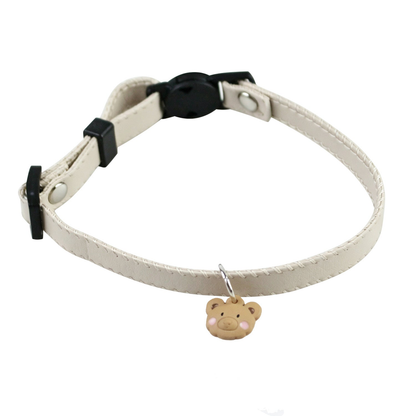 Ivory cat collar with black buckle and bear-face charm