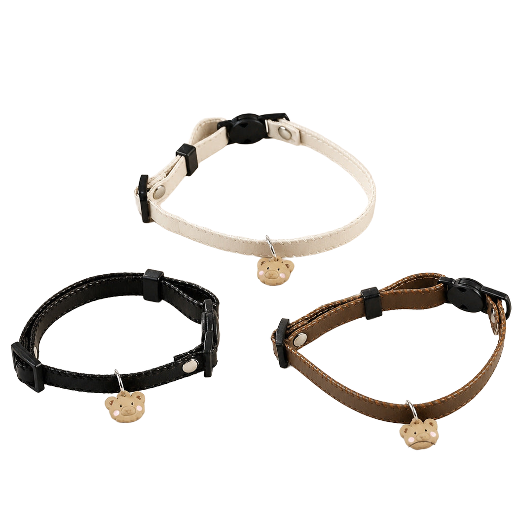 Ivory, Black, and Brown cat collars with bear-face charms displayed together