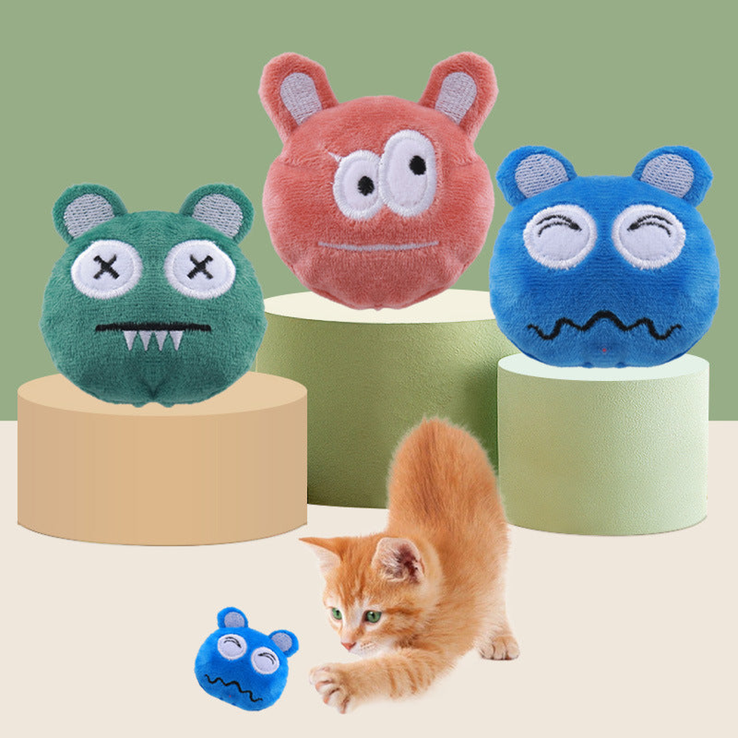 Orange Red, Green and Blue monster-face cat toys displayed with a cat