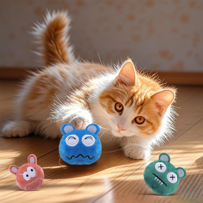 Cat playing beside Orange Red, Green and Blue monster-face cat toys