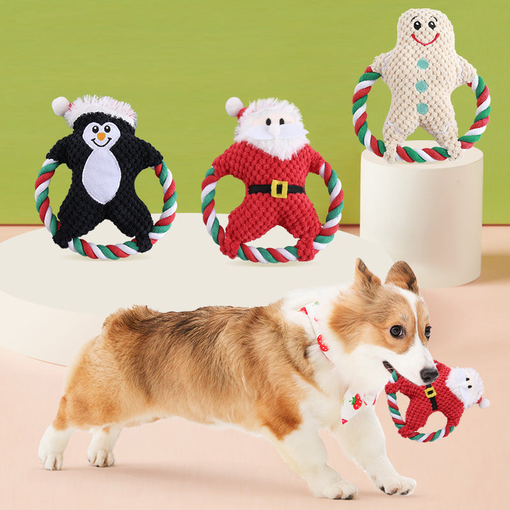 Penguin, Santa, and gingerbread character dog toys displayed with a dog holding the Santa style