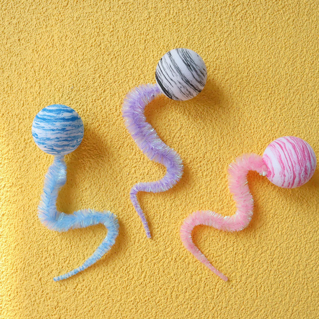Blue, gray, and pink striped ball-and-tail cat toys with curved fuzzy tails