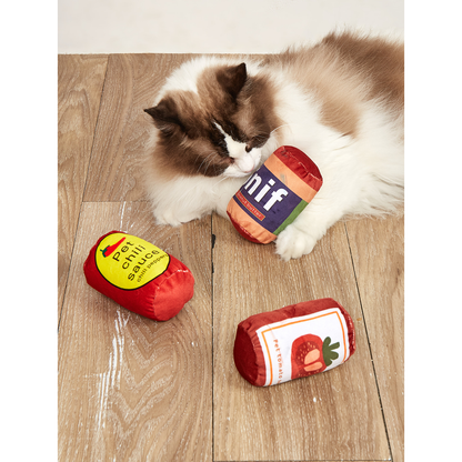 Cat playing with Peanut Butter, Tomato and Chili can-shaped toys
