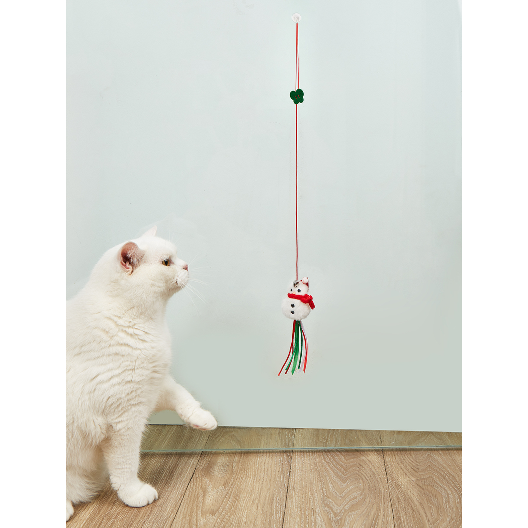 Cat reaching toward a hanging Snowman cat toy