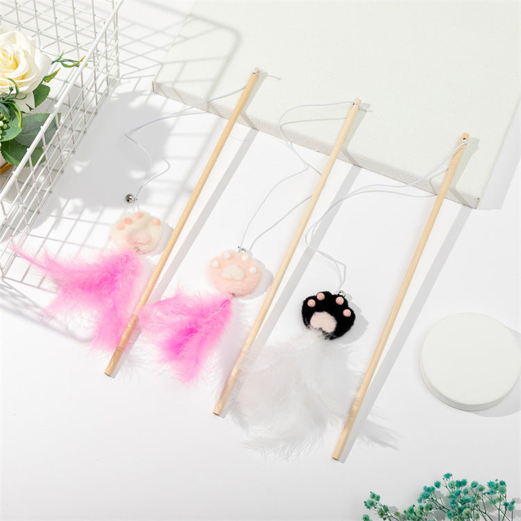 Pink, black and white paw cat teaser wands displayed together