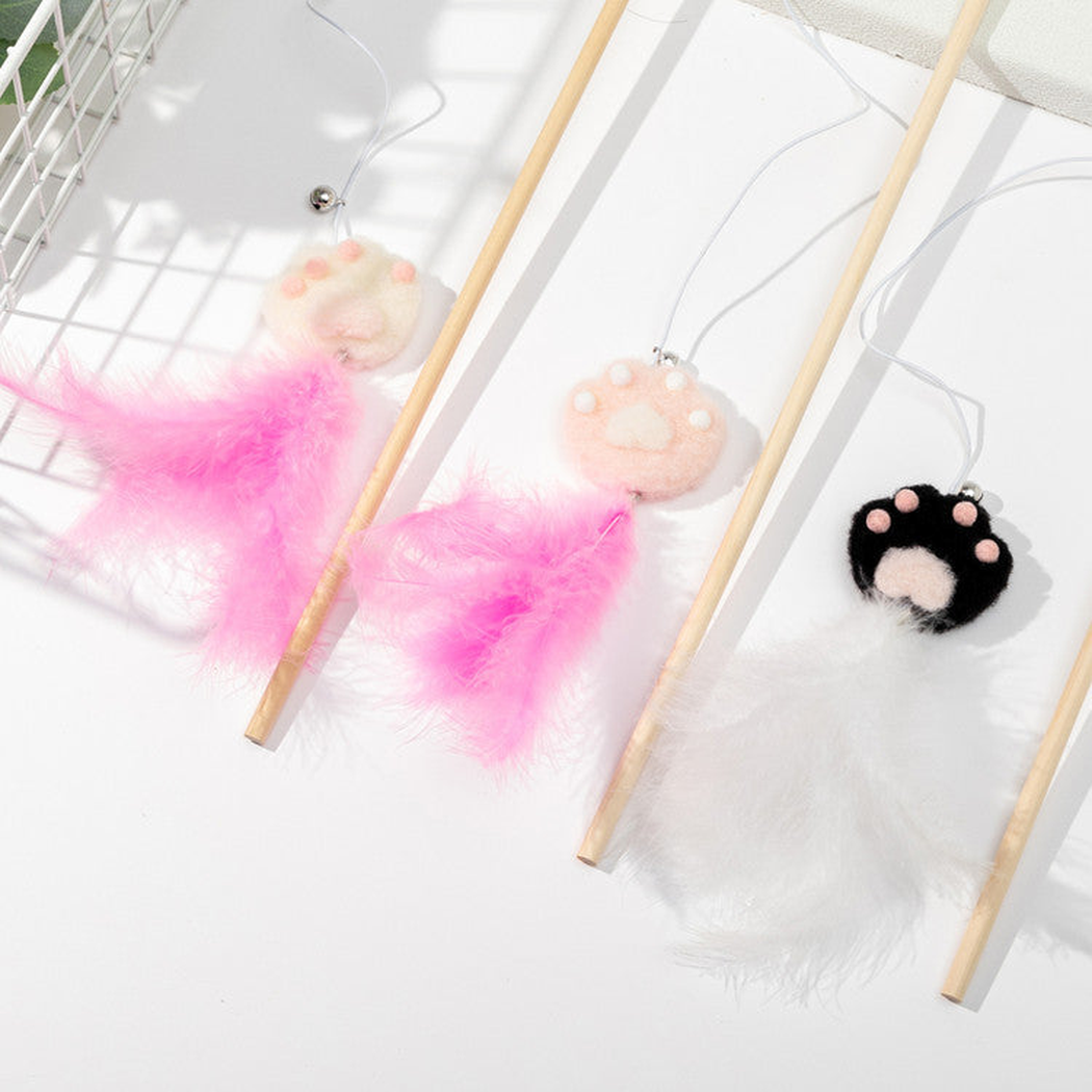 Close-up of three paw ornaments, feather tassels and teaser wand cords