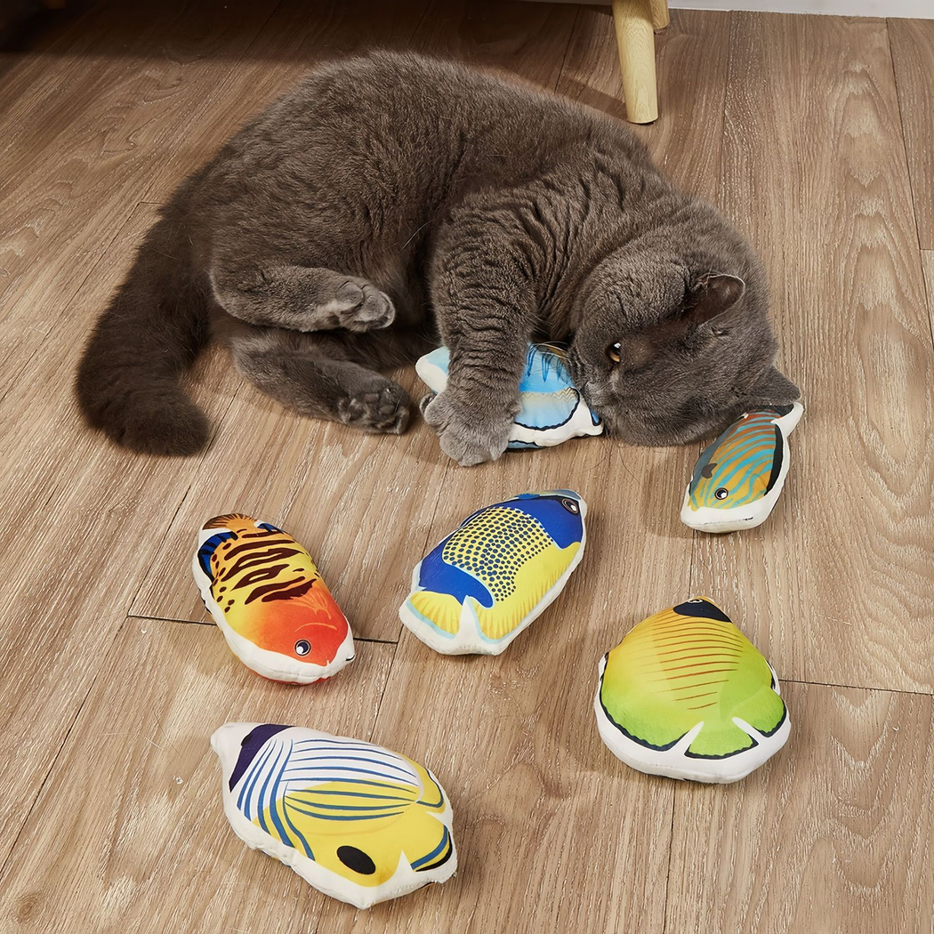 Cat playing with colorful fish-shaped cat toys on a wood floor