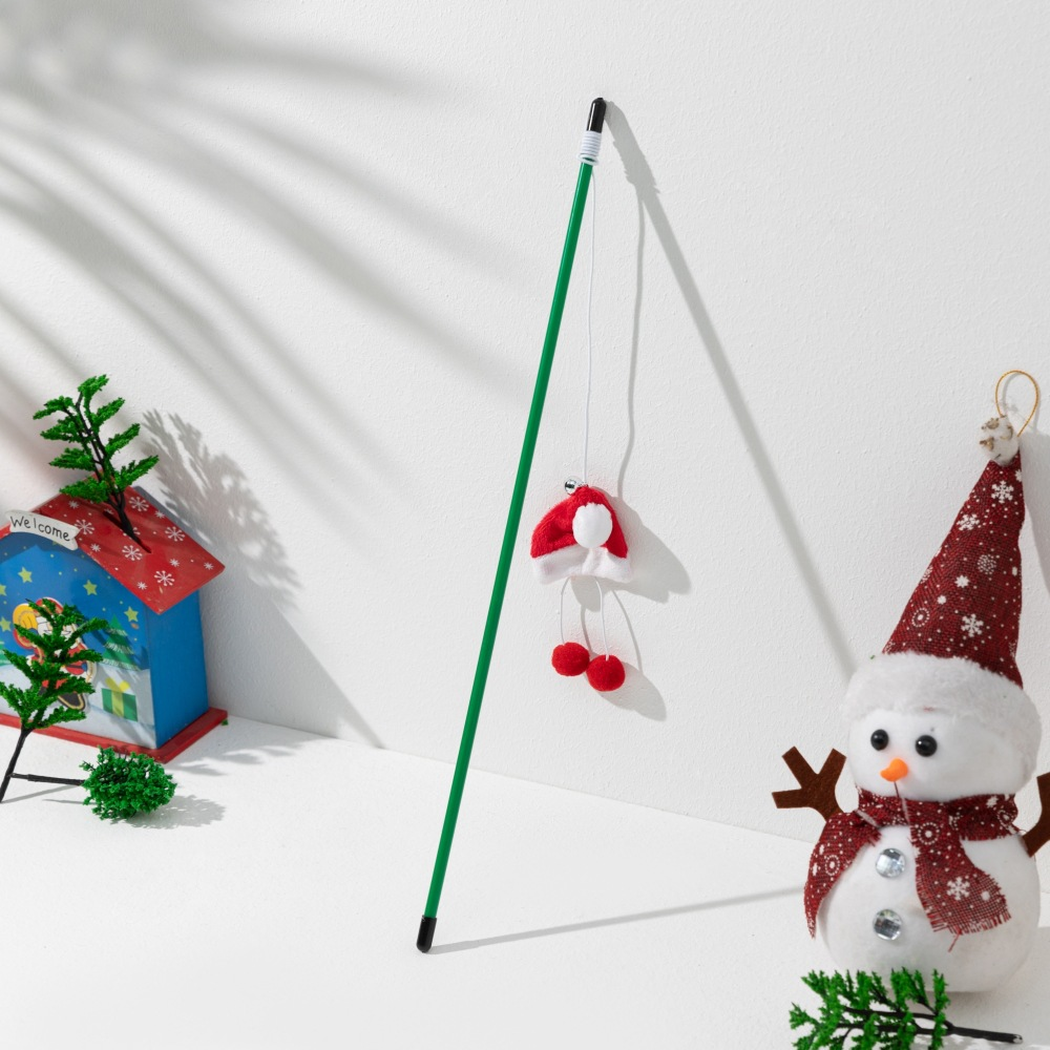 Green cat teaser wand with a red Santa hat ornament and red pom-poms