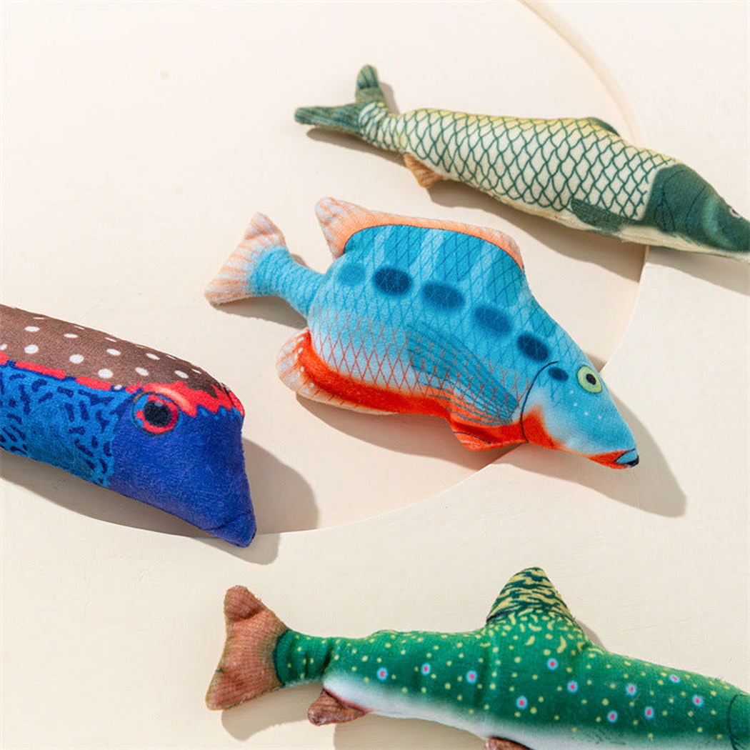 Close overhead arrangement of four colorful fish-shaped cat toys