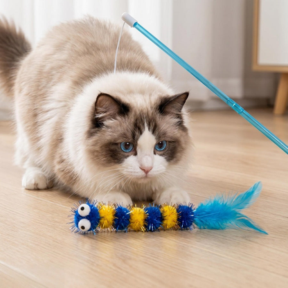 Cat crouching beside a blue caterpillar teaser wand