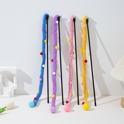 Four fuzzy cat teaser wands standing against a white wall